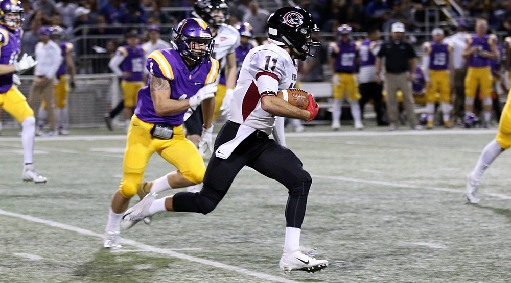 Dominic Vaccher runs away from a Cal Lutheran defender en route to some of his 307 receiving yards. (Cal Lutheran athletics photo by Larry Newman)